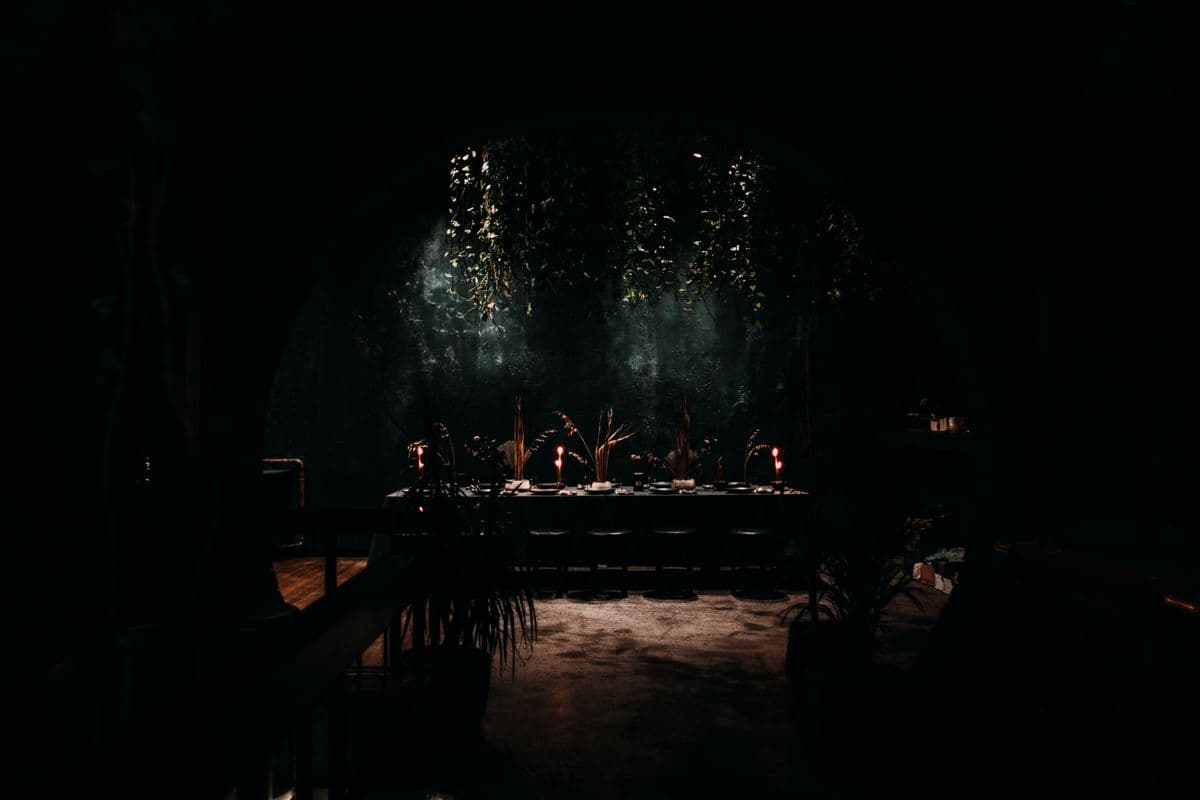 Candlelit private-event table in a dark, refined interior.