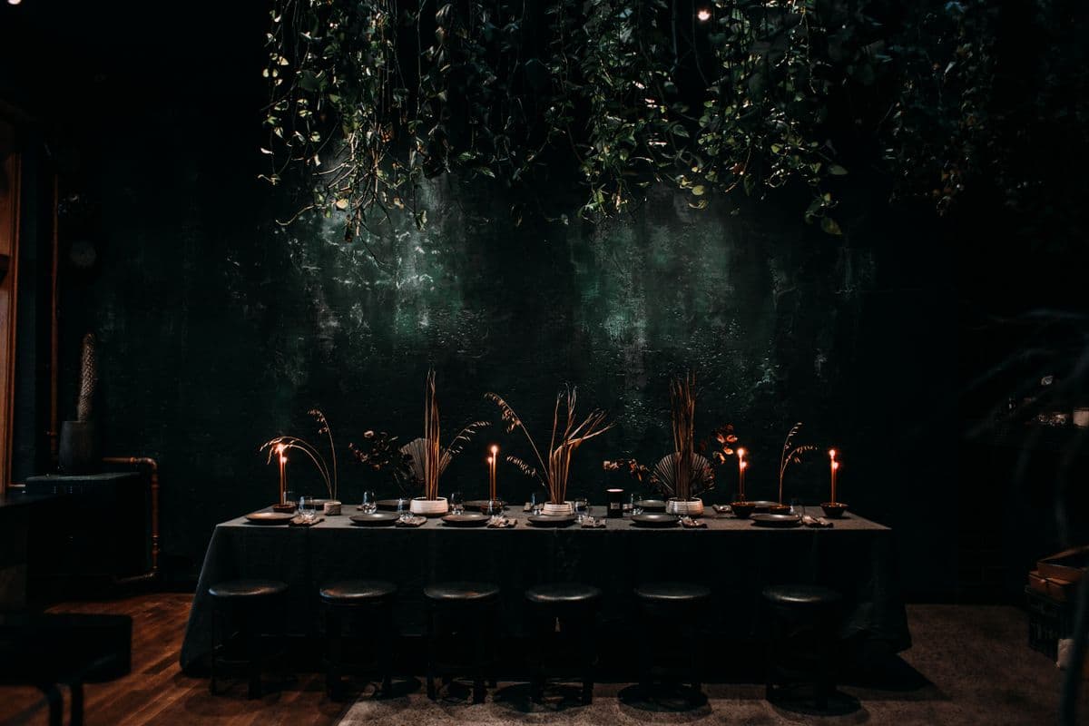 Long candlelit table prepared for an elegant private gathering.